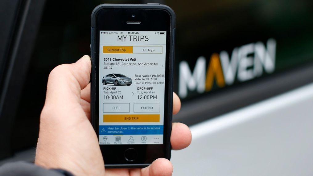 A smartphone displaying the Maven app, a General Motors car-sharing service, is shown, in Ann Arbor, Mich. General Motors Co. launched its Maven car-sharing service in New York on Monday, May 15, 2017. The service lets members rent a variety of GM vehicles for whatever they need, from a 30-minute errand to a 28-day road trip. (AP Photo/Paul Sancya, File)