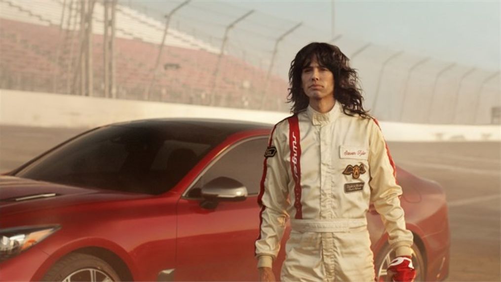 The all-new 2018 Kia Stinger GT’s twin-turbo, 365-horsepower engine is put to use – in reverse – sending Steven Tyler on a transformative journey back to the seventies. (Image courtesy of Kia Motors America)