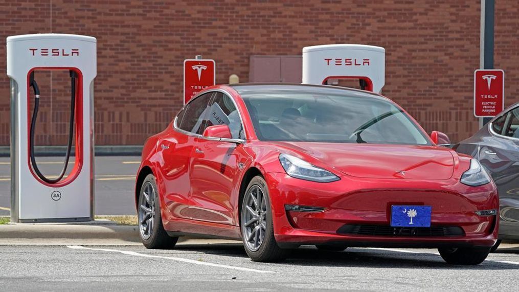 This Friday, July 19, 2019, file photo shows a Tesla vehicle charging at a Tesla Supercharger site in Charlotte, N.C. Tesla’s electric car sales accelerated again during the summer, but the company is still lagging behind the pace it needs to reach CEO Elon Musk’s goal for the entire year. (AP Photo/Chuck Burton, File)