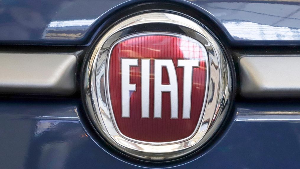 FILE - In this Feb. 14, 2019, file photo, the Fiat logo is mounted on a 2019 500 L on display at the 2019 Pittsburgh International Auto Show in Pittsburgh.  argainers for the United Auto Workers union and Fiat Chrysler are close to reaching a tentative deal on a new four-year contract, a person briefed on the matter said Saturday, Nov. 30.  The deal, which could be announced Saturday, includes a $9,000 signing bonus, a promise not to close any factories for the next four years and a commitment to keep making vehicles at a plant in Belvidere, Illinois, said the person, who spoke on condition of anonymity because the talks are confidential.  (AP Photo/Gene J. Puskar, File)