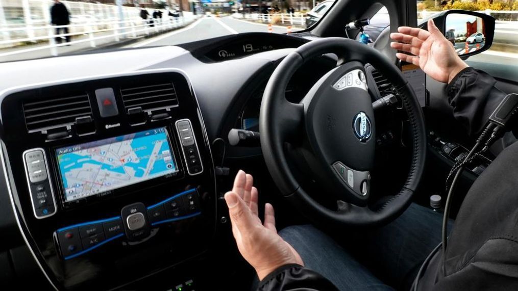 In this Wednesday, Feb. 21, 2018, photo, Nissan Motor Co.'s staff member gets his hands off of the steering wheel of its Easy Ride robo-vehicle during a test ride on a course in Yokohama, near Tokyo. Starting next month, Nissan is testing on regular roads what it calls “a robo-vehicle mobility service.” Called Easy Ride, it uses a cell-phone app to book semi-autonomous driven rides. (AP Photo/Shizuo Kambayashi)