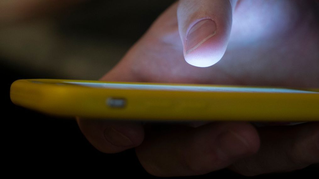 FILE - In this Sunday, Aug. 11, 2019, photo, a man uses a cell phone in New Orleans. (AP Photo/Jenny Kane, File)