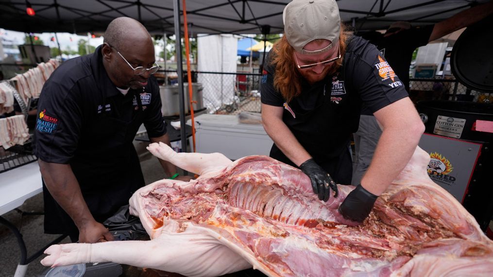 The Shed BBQ and Blues Joint team members Hobson Cherry, left, and James Newell season a whole hog as they compete at the World Championship Barbecue Cooking Contest, Friday, May 17, 2024, in Memphis, Tenn. (AP Photo/George Walker IV)