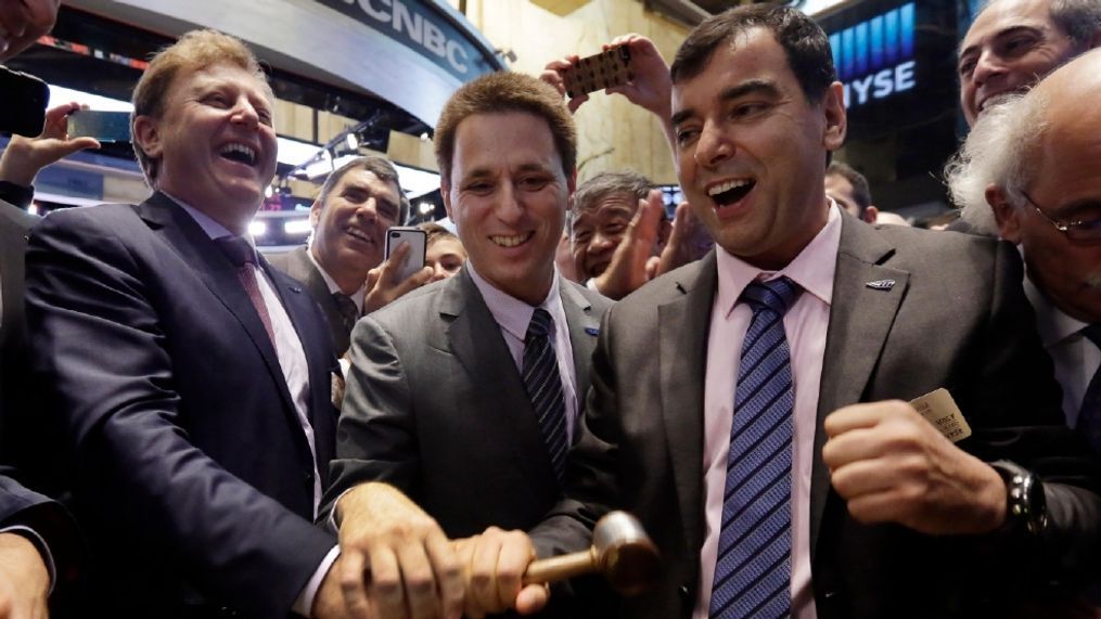 In this August 2014 photo, Mobileye President & CEO Ziv Aviramon, left, CFO Ofer Maharshak, center, and Chairman Amnon Shashua, clasp hands to ring a ceremonial bell as their company's IPO begins trading, on the floor of the New York Stock Exchange.   (AP Photo/Richard Drew, File)