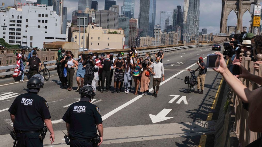 NYPD stand on the Brooklyn Bridge as Black Lives Matter protester Wednesday, July 15, 2020, in New York.  Several New York City police officers were attacked and injured Wednesday on the Brooklyn Bridge during a protest sparked by the death of George Floyd. Police say at least four officers were hurt, including the department’s chief, and more than a dozen people were arrested. (AP Photo/Yuki Iwamura)