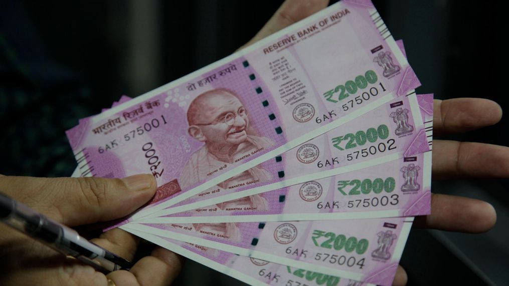 FILE- In this Nov. 13, 2016 file photo, an Indian holds 2000 rupee currency notes in Jammu, India. (AP Photo/Channi Anand, File)