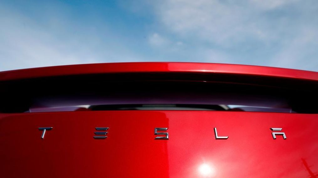 In this April 15, 2018, file photo, the sun shines off the rear deck of a roadster on a Tesla dealer's lot in the south Denver suburb of Littleton, Colo. Electric car producer Tesla says it will build its first factory outside the United States in Shanghai. Tesla says an agreement signed Tuesday, July 10, with a Shanghai city government agency calls for construction to start in the near future. (AP Photo/David Zalubowski, File)