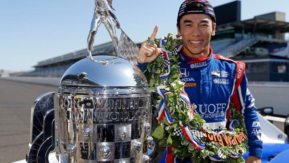 Indianapolis 500 champion Takuma Sato, of Japan, poses with the Borg-Warner Trophy during the traditional winners photo session on the start/finish line at the Indianapolis Motor Speedway in Indianapolis, Monday, May 29, 2017. (AP Photo/Michael Conroy)