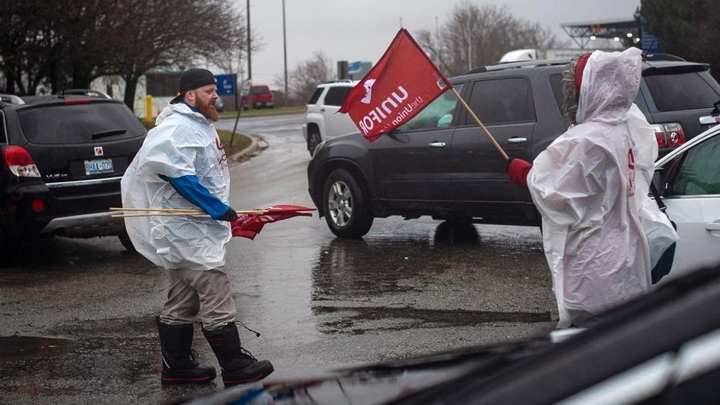 Members of Unifor, the union representing the workers of Oshawa's General Motors assembly plant, stand near the entrance to the plant in Oshawa, Ontario, Monday, Nov. 26, 2018. General Motors will lay off thousands of factory and white-collar workers in North America and put five plants up for possible closure as it restructures to cut costs and focus more on autonomous and electric vehicles. General Motors is closing the Oshawa plant. (Eduardo Lima/The Canadian Press via AP)