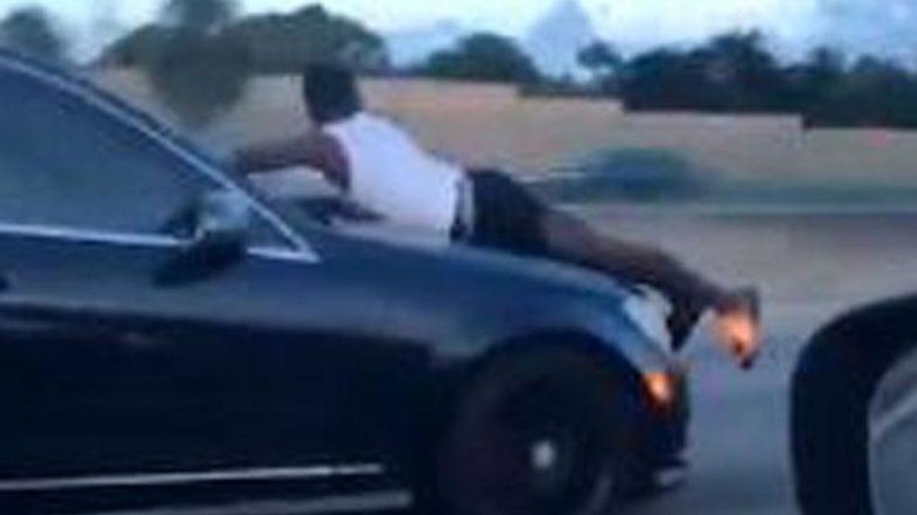 Video shows man riding on hood of car. (Twitter/@danimidah)