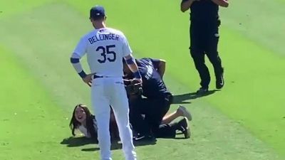 Image for story: Woman tackled after running on the  field to hug Dodgers' Cody Bellinger