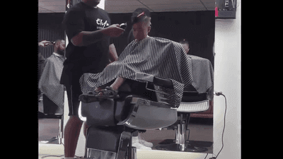 Image for story: HILARIOUS: Young boy falls asleep in barber chair while getting haircut