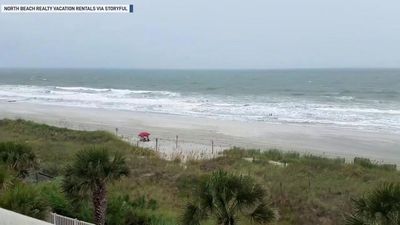 Image for story: Couple ignore Hurricane Dorian's approach and lounge on South Carolina beach