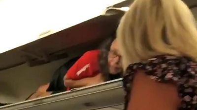 Image for story: Passenger bemused after seeing flight attendant in overhead luggage compartment