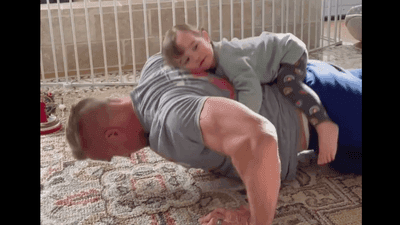 Image for story: ADORABLE: Daughter jumps on father's back during his pushup routine 