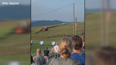 Image for story: Farmer pays respect to national anthem during football game