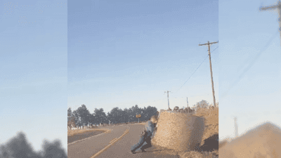 Image for story: Super trooper flexes his 'leg day' prowess by removing rogue hay bale from road