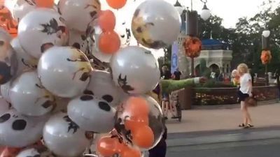 Image for story: Wind nearly carries away balloon handler at 'Mickey's Not-So-Scary Halloween Party'