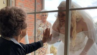 Image for story: Woman visits grandma through window of assisted living home in her wedding gown