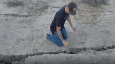 Image for story: Man reaches into fissure following earthquakes in Southern California