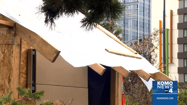 An encampment of the unhoused at Fairview Ave and Mercer Street in Seattle, where two people are building a tiny house. (KOMO)