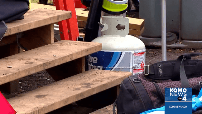 An encampment of the unhoused at Fairview Ave and Mercer Street in Seattle, where two people are building a tiny house. (KOMO)