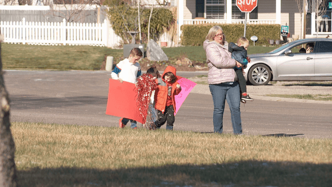 Kids line streets for teacher parade. (KUTV)