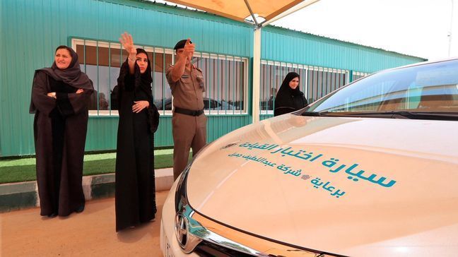 This image released by the Saudi Information Ministry, a Saudi woman speaks to an officer before her driving exam, at the General Department of Traffic in the capital, Riyadh, Monday, June 4, 2018. (Photos by Saudi Information Ministry via AP)