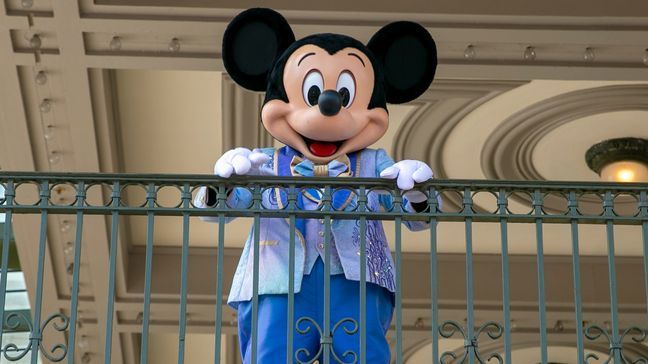 FILE - An actor dressed as Mickey Mouse greets visitors at the entrance to Magic Kingdom Park at Walt Disney World Resort, April 18, 2022, in Lake Buena Vista, Fla. (AP Photo/Ted Shaffrey, File)