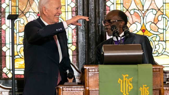 President Joe Biden waves to attendees as Bishop Samuel L. Green, Sr. looks on before Biden delivers remarks at Mother Emanuel AME Church in Charleston, S.C., Monday, Jan. 8, 2024, where nine worshippers were killed in a mass shooting by a white supremacist in 2015. . (AP Photo/Mic Smith)