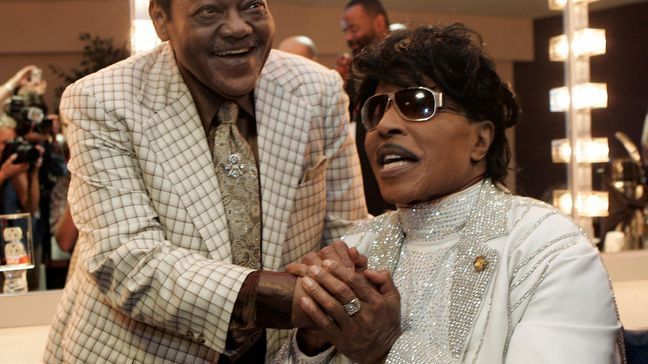 FILE - In this May 30, 2009 file photo, Fats Domino visits with Little Richard in a dressing room after Richards' performance at The Domino Effect, a tribute concert for Domino, at the New Orleans Arena in New Orleans. (AP Photo/Patrick Semansky, File)