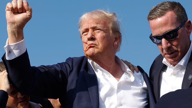 Republican presidential candidate former President Donald Trump pumps his fist as he is rushed offstage by U.S. Secret Service agents after being grazed by a bullet during a rally on July 13, 2024 in Butler, Pennsylvania. Butler County district attorney Richard Goldinger said the shooter is dead after injuring former U.S. President Donald Trump, killing one audience member and injuring another in the shooting. (Photo by Anna Moneymaker/Getty Images)