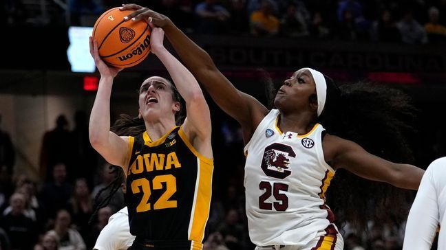 South Carolina guard Raven Johnson (25) blocks a shot by Iowa guard Caitlin Clark (22) during the first half of the Final Four college basketball championship game in the women's NCAA Tournament, Sunday, April 7, 2024, in Cleveland. (AP Photo/Carolyn Kaster)