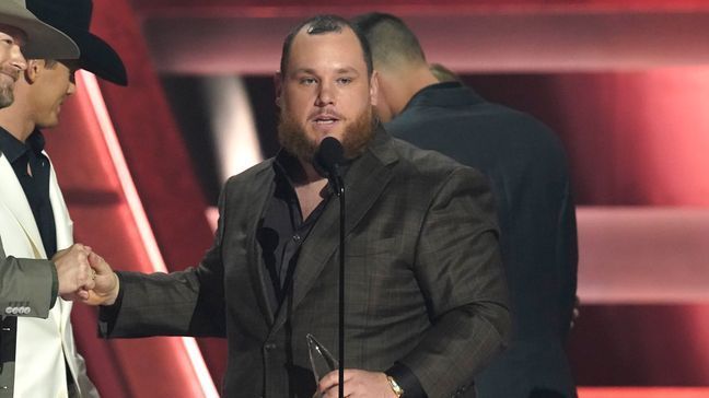 Presenter Brian Kelley, left, shakes hands with Luke Combs as he appears on stage to accept the award for single of the year for "Fast Car" at the 57th Annual CMA Awards on Wednesday, Nov. 8, 2023, at the Bridgestone Arena in Nashville, Tenn. (AP Photo/George Walker IV)