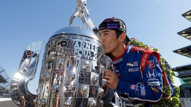 Indianapolis 500 champion Takuma Sato, of Japan, kisses the Borg-Warner Trophy during the traditional winners photo session on the start/finish line at the Indianapolis Motor Speedway in Indianapolis, Monday, May 29, 2017. (AP Photo/Michael Conroy)