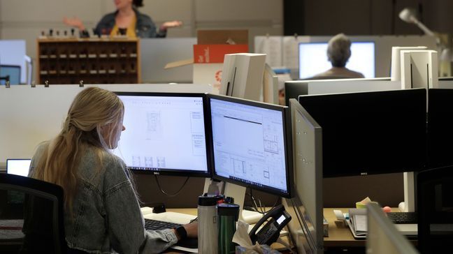 FILE - An architectural designer works at a computer as an accounting manager speaks with a colleague Wednesday, July 29, 2020, in Boston. (AP Photo/Steven Senne)