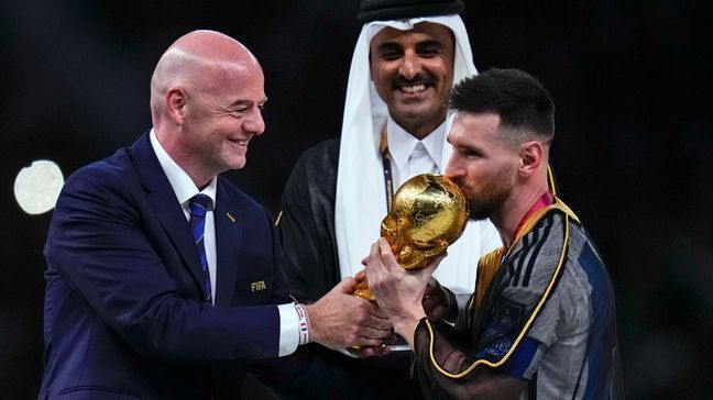 FILE - Argentina's Lionel Messi kisses the trophy presented by FIFA President Gianni Infantino, left, as The Emir of Qatar Sheikh Tamim bin Hamad Al Thani looks on, after the World Cup final soccer match between Argentina and France at the Lusail Stadium in Lusail, Qatar, Sunday, Dec. 18, 2022. The expanded World Cup in North America got even more supersized on Tuesday, March 14, 2023, The governing body of soccer increased the size of the 2026 tournament for the second time — six years after the first — by approving a bigger group stage for the inaugural 48-team event. (AP Photo/Manu Fernandez)