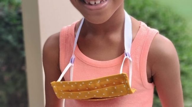 Little girl wearing a mask lanyard Erica Gooden made by hand. (Source: Erica Gooden){p}{/p}