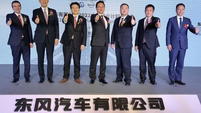 Dongfeng President Jun Seki, center, poses with his company's executives on stage after a press conference on the company's 2018-2022 midterm plan in Beijing, Monday, Feb. 5, 2018. Nissan will start sales of its all-electric Leaf in China this year and develop 20 electric models with its Chinese partner over the next five years, the companies said Monday. The electric vehicles are part of a 60 billion yuan ($10 billion) investment plan through 2020 for Nissan Motor Co. and Dongfeng Motor Ltd. (AP Photo/Andy Wong)