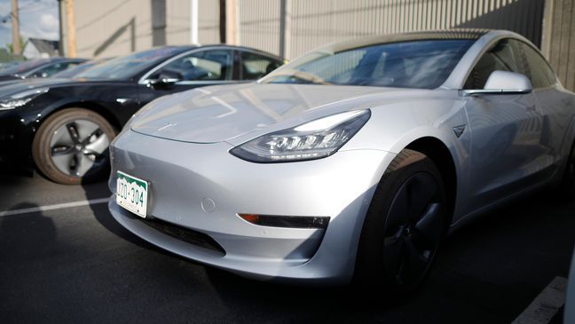 In this Sunday, May 27, 2018, photo a pair of 2018 Model 3's sit at a Tesla dealership in Littleton, Colo. A wireless update of antilock braking software improved the stopping distance of Tesla's electric Model 3, prompting Consumer Reports to reverse course and give the car its "Recommended Buy" rating. The magazine said Wednesday, May 30, that the update cut 19 feet off the car's stopping distance from 60 miles per hour. (AP Photo/David Zalubowski)