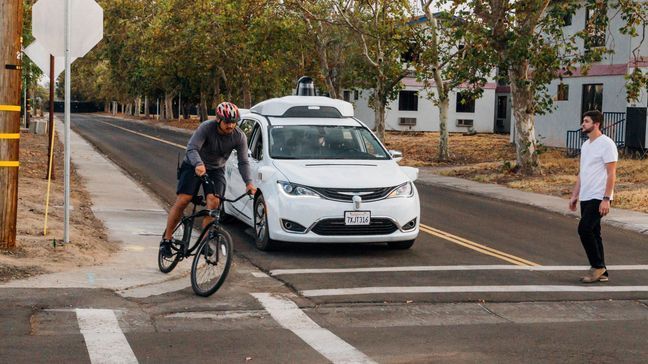 This Sunday, Oct. 29, 2017, photo provided by Waymo shows a Chrysler Pacifica minivan equipped with Waymo's self-driving car technology, being tested with the company's employees as a biker and a pedestrian at Waymo's facility in Atwater, Calif. Waymo, hatched from a Google project started eight years ago, showed off its progress Monday during a rare peek at a closely guarded testing facility located 120 miles southeast of San Francisco where its robots complete their equivalent to driver's education. (Julia Wang/Waymo via AP)