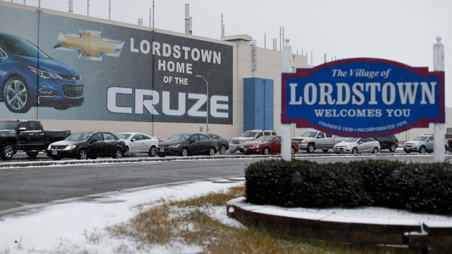 FILE - In this Nov. 27, 2018, file photo, a banner depicting the Chevrolet Cruze model vehicle is displayed at the General Motors' Lordstown plant, in Lordstown, Ohio. GM employees in Lordstown and other factories in Michigan and Maryland that are targeted to close within a year say moving will force them to leave behind relatives, even their children, in some cases. (AP Photo/John Minchillo, File)