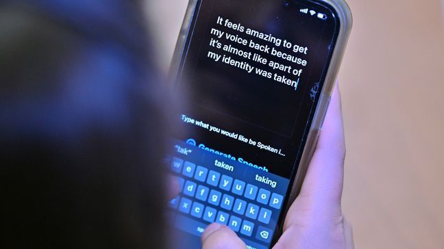 Alexis Bogan types a response to a reporter's question with an app which approximates her lost voice, Thursday, March 11, 2024, at Rhode Island Hospital in Providence, R.I. (AP Photo/Josh Reynolds)