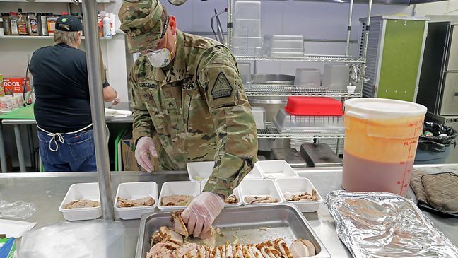 Alaska Army National Guard Sgt. David Osmanson, assigned to the AKARNG Recruting and Retention Battalion, prepares sliced turkey entrees for prepackaged hot lunches in the kitchen at Bean's Cafe in Anchorage, Apr. 8, 2020. "We couldn't do what we're doing without these Soldiers' help," said Scott Lingle, Food Service director of Bean's Cafe. "We appreciate the labor, the attitude and the willingness to help." (Alaska Army National Guard photo by Sgt. Seth LaCount/Released)