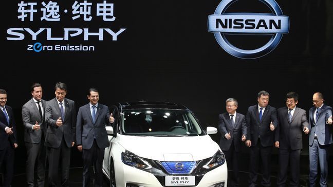 Nissan officials pose for photos with the newly unveiled Sylphy Zero Emission during the start of the Auto China 2018 in Beijing, China, Wednesday, April 25, 2018. Volkswagen and Nissan have unveiled electric cars designed for China at the Beijing auto show that highlights the growing importance of Chinese buyers for a technology seen as a key part of the global industry's future.(AP Photo/Ng Han Guan)