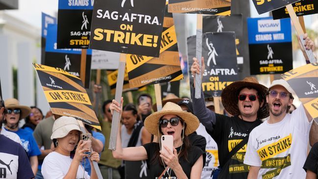 FILE - Picketers carry signs on the picket line outside Netflix on Wednesday, Sept. 27, 2023, in Los Angeles.{&nbsp;} (AP Photo/Chris Pizzello)