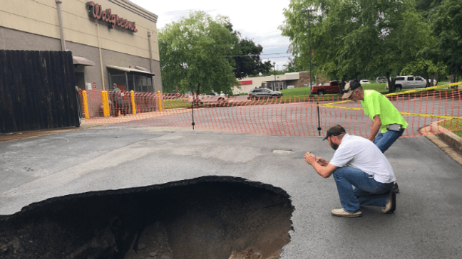 Officials are taking in the damage after a sinkhole opened up in the parking lot of a Chattanooga Walgreens Thursday. (Image: WTVC)