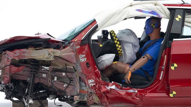 The dummy's position in relation to the door frame, steering wheel and instrument panel on the 2019 Tesla Model 3 after the crash test indicates that the driver's overall survival space was maintained well, despite moderate intrusion of the lower part of the door hinge pillar and buckling of the door sill. (Image courtesy of the Insurance Institute for Highway Safety)