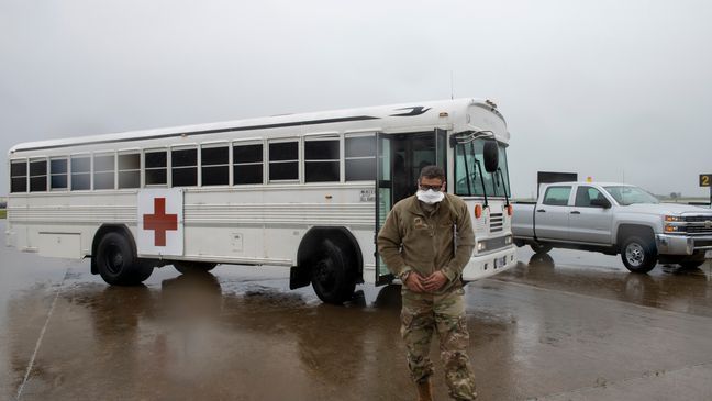 U.S. Air Force Capt. Luke Vera, 60th Dental Squadron, exits a medical bus April 5, 2020, at Travis Air Force Base, California. (U.S. Air Force photo by Tech. Sgt. James Hodgman){p}{/p}